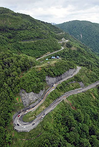 新緑がきれいな山肌の脇を抜け、半年ぶりに開通した山岳道路「白山スーパー林道」＝白川村で、本社ヘリ「わかづる」から

